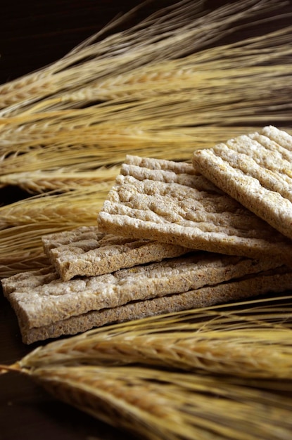 Iet-Brot und Weizenähren auf dunklem Hintergrund.