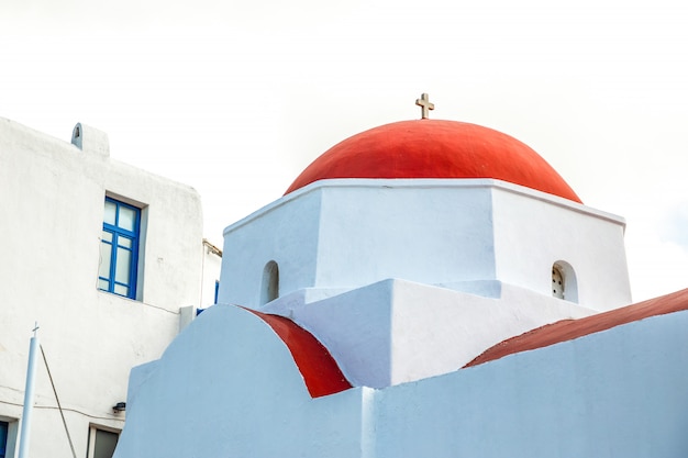 Iglesia Agia Kyriaki, típica iglesia griega edificio blanco con cúpula roja contra el cielo azul en la isla de Mykonos, Grecia