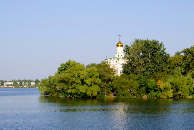 Iglesia en los árboles en la orilla del río.