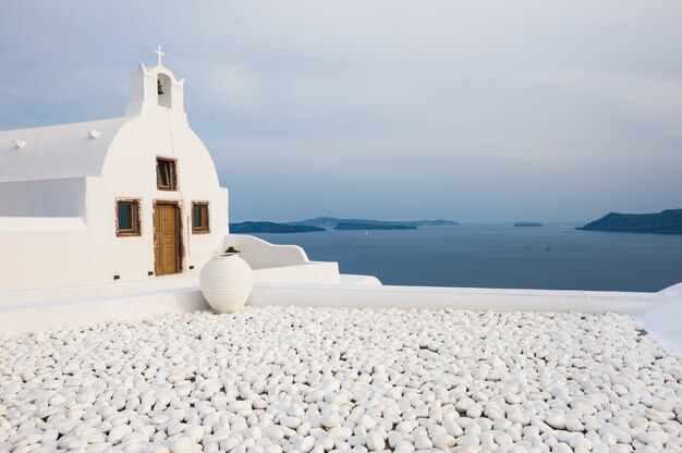 Iglesia blanca en la isla de Santorini, Grecia. Hermoso paisaje al atardecer, vista al mar