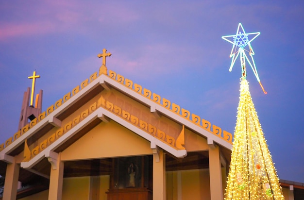 Iglesia católica con árbol de Navidad y luces de noche