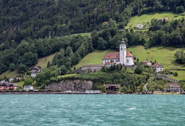 Una iglesia en una colina con un lago al fondo