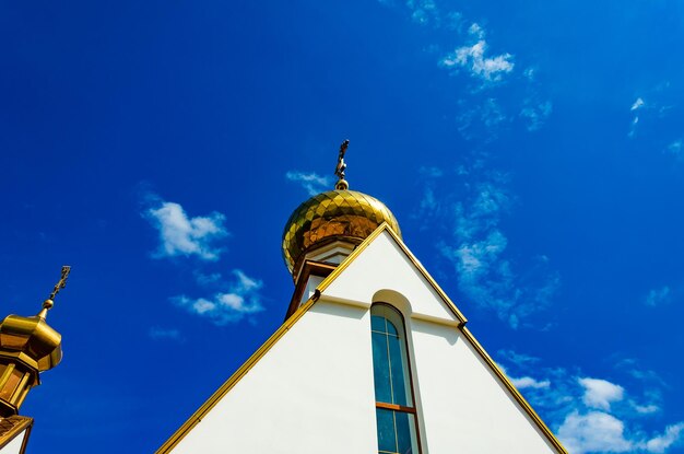 Una iglesia con una cúpula dorada y una cruz encima