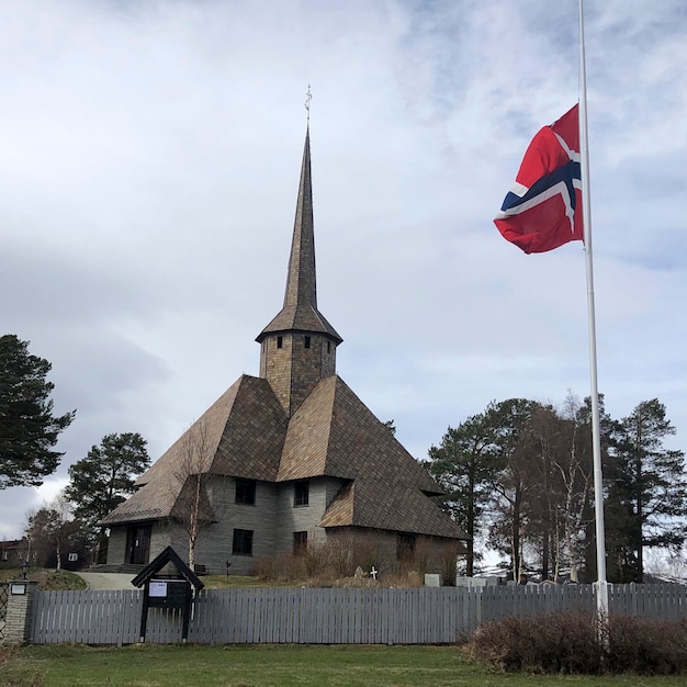 Iglesia Dombas con bandera noruega. Antigua iglesia tradicional de Noruega. La mejor arquitectura noruega