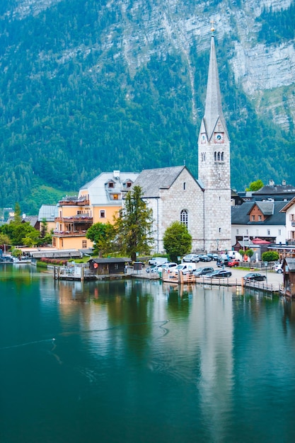 Iglesia evangélica de hallstatt en las montañas de los alpes de la orilla del lago en el fondo