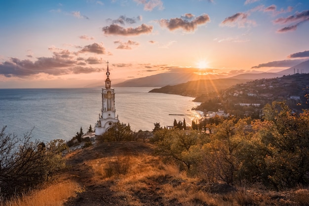 Iglesia del faro al atardecer. Costa del mar negro.