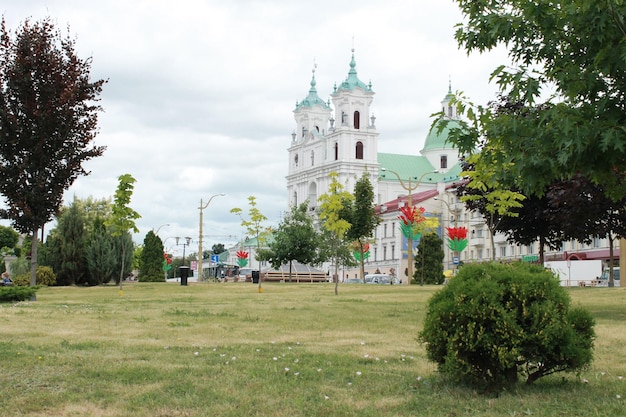 Una iglesia grande con un techo verde y una iglesia en el fondo