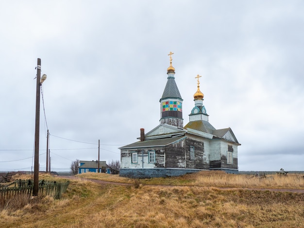 Iglesia Kashkarantsy auténtica de madera. Un pequeño pueblo auténtico en la costa del mar Blanco. Península de Kola. Rusia.