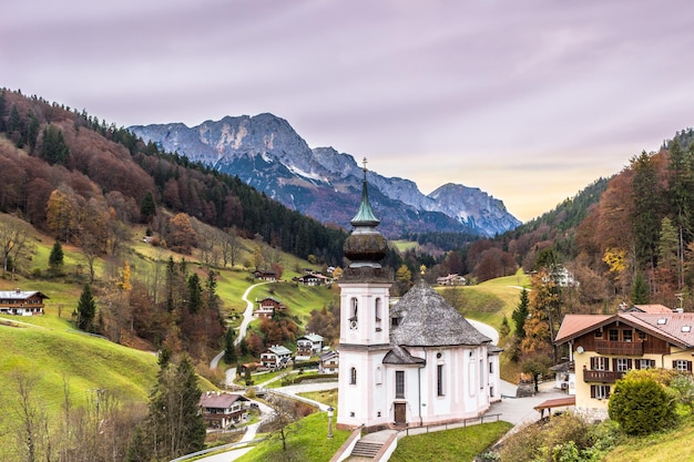 Iglesia de Maria Gern, pueblo bávaro y montañas sobre un fondo al amanecer. Alpes bávaros. Berchtesgadener Land, Baviera, Alemania