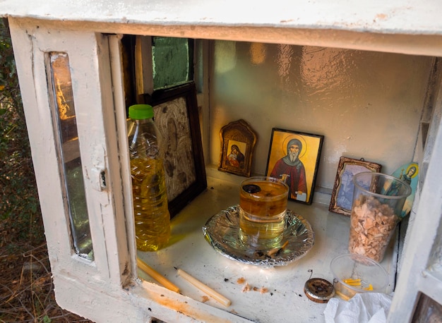 Iglesia en miniatura tradicional de Candelakia con una vela encendida e íconos en Grecia