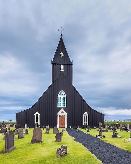 Una iglesia negra con un cementerio al fondo.