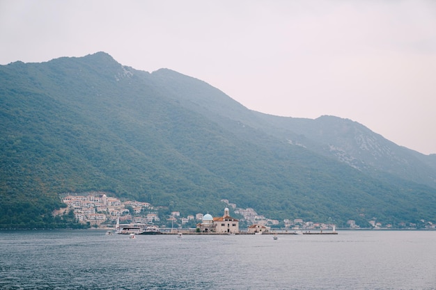 Iglesia de nuestra señora en las rocas con el telón de fondo de perast montenegro