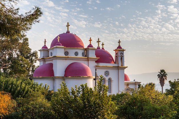 La Iglesia Ortodoxa Griega de los Santos Apóstoles por el Mar de Galilea en Capernaum Israel cúpulas rosas cruces doradas edificio blanco