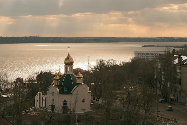 Iglesia ortodoxa de popa en el río Cielo moviéndose con rayos de dios Skylapse de la iglesia con cúpulas doradas Cúpula de la iglesia que refleja el cielo flotante