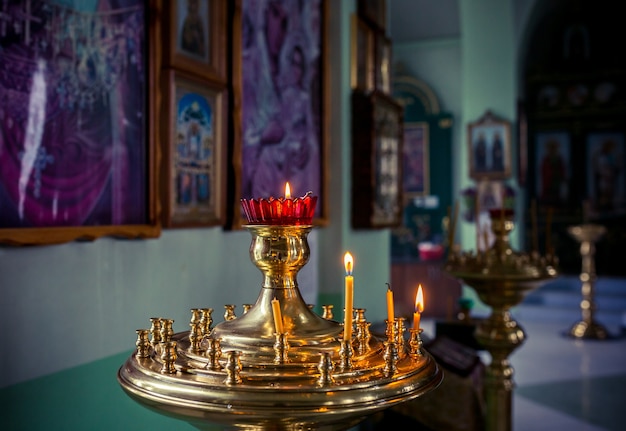 En una iglesia oscura, las velas arden brillantemente con una llama amarilla