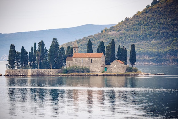 Una iglesia en una pequeña isla con una montaña al fondo.