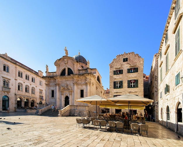 La iglesia de San Blas en la calle Stradun y la gente en el café de la ciudad vieja de Dubrovnik, Croacia