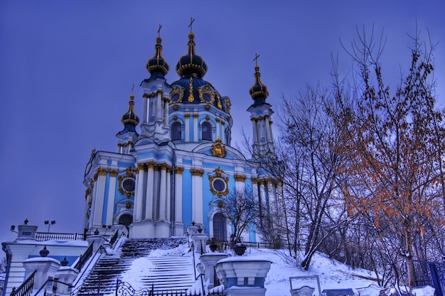 Foto una iglesia con un techo azul y dorado y una valla negra