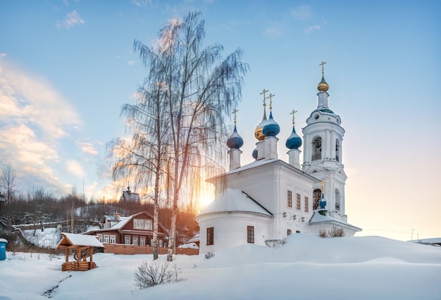 Iglesia de Varvara con un campanario y el monte Levitan en Plyos en la nieve a la luz del sol poniente de invierno.