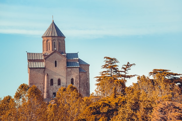 Igreja antiga entre a floresta de outono. Georgia.