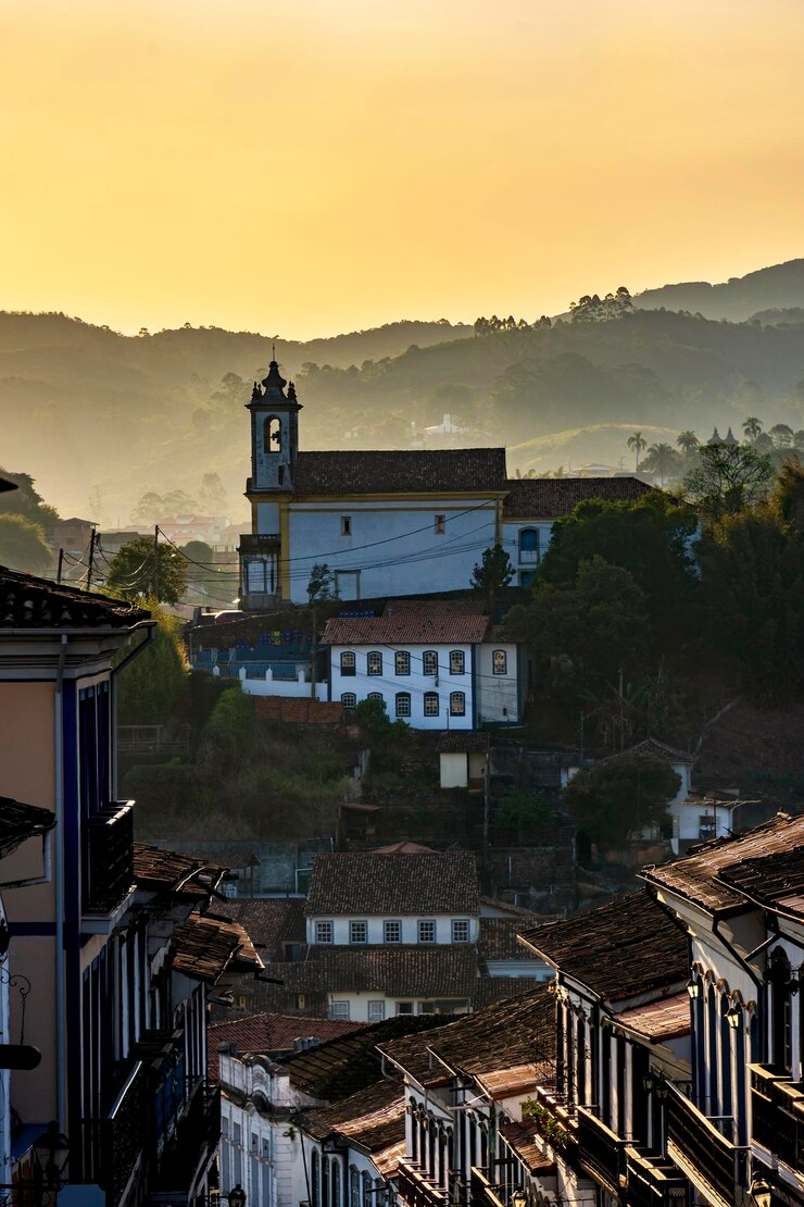 Foto igreja antiga vista na cidade de ouro preto durante o pôr-do-sol com suas casas em arquitetura colonial