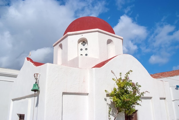 Igreja com cúpula vermelha em Mykonos, Grécia. Arquitetura do edifício da capela. Igreja branca no céu azul. Férias de verão na ilha mediterrânea, desejo de viajar. Conceito de religião e culto.