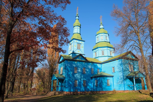 Igreja de madeira azul ortodoxa no parque outono em Pereyaslav Khm
