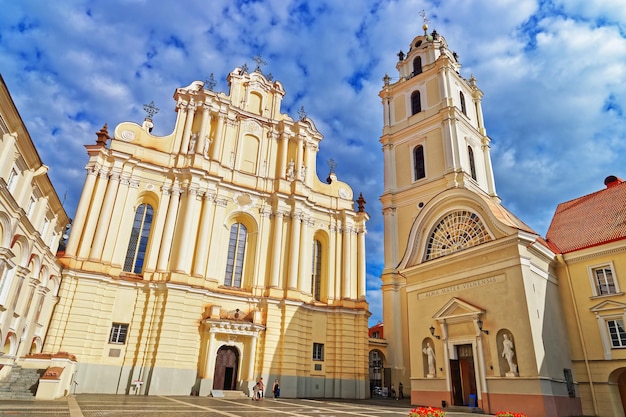 Igreja de São João e sua torre sineira no Grande pátio da Universidade de Vilnius, Vilnius, Lituânia. Pessoas no fundo