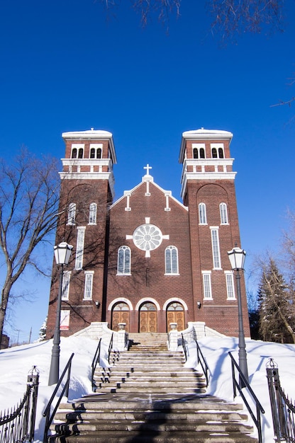 Foto igreja de tijolos de torre dupla contra um céu azul