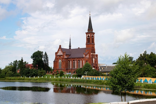 Igreja de tijolos vermelhos pelo rio e céu nublado