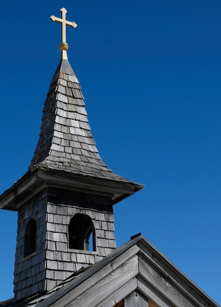 Igreja no sol da neve debaixo de um céu azul