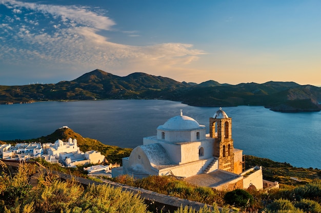 Igreja ortodoxa grega na aldeia de plaka, na ilha de milos, ao pôr do sol na grécia
