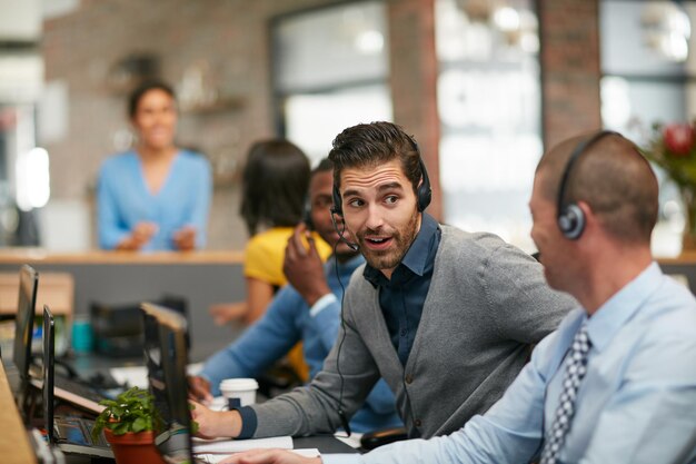 Foto ihm bei einem anruf einen rat geben schnappschuss einer gruppe von kreativprofis, die im büro arbeiten