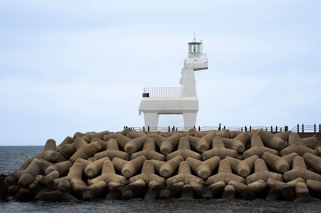 Iho Tewoo White Pony Horse Leuchttürme und Tetrapoden für Wellenbrecher und Wellenwasserableitung verhindern Erosion im Meer am Strand von Iho Tewoo für Koreaner, die auf der Insel Jeju in Südkorea reisen