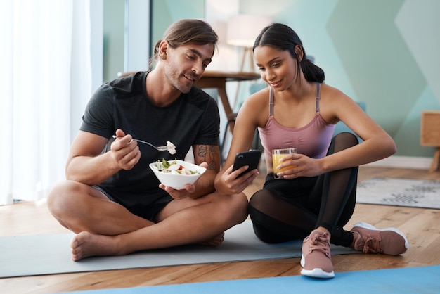 Ihre Ernährung ist genauso wichtig wie Ihr Training Ganzkörperaufnahme eines sportlichen jungen Paares, das nach dem Training zu Hause ein paar gesunde Snacks genießt