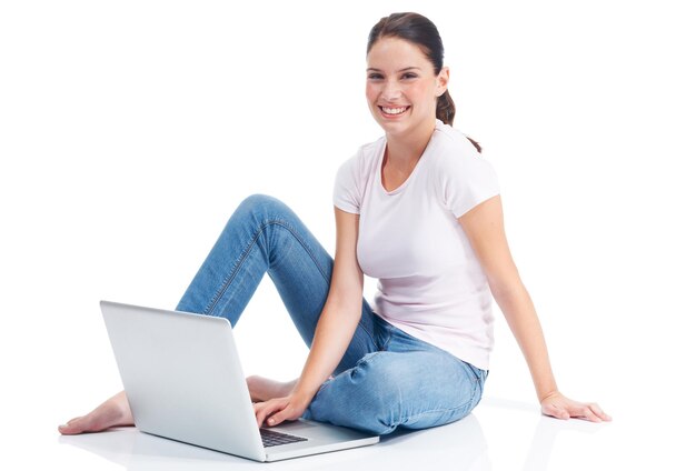 Ihre Gedanken mit der Welt teilen Glückliche junge Frau, die mit ihrem Laptop auf dem Boden sitzt