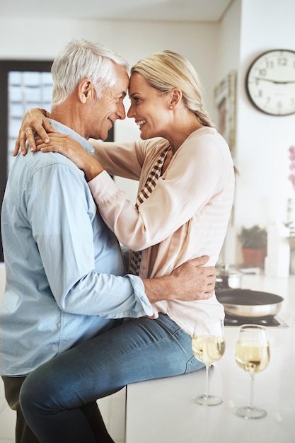 Ihre Liebe wächst jeden Tag. Schnappschuss eines liebevollen, reifen Paares, das einen intimen Moment in seiner Küche teilt