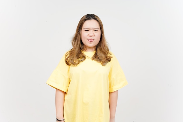 Ihre Zunge herausstrecken Schöne asiatische Frau mit gelbem T-Shirt isoliert auf weißem Hintergrund