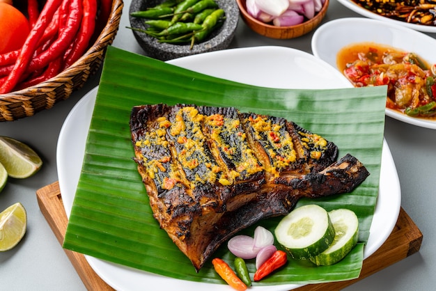 Ikan Pari Bakar oder gegrillter Stachelrochen in Chili-Curry-Sauce serviert auf Bananenblatt