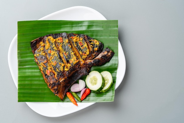 Ikan Pari Bakar oder gegrillter Stachelrochen in Chili-Curry-Sauce serviert auf Bananenblatt