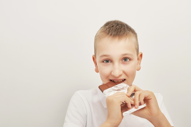 Ild¡Niño con conejitos de chocolate y huevos de pascua. Huevos de chocolate, conejos y azulejos. Dulces de chocolate para niños