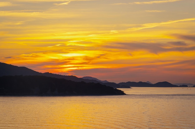 Ilha de silhueta com pôr do sol em um fundo claro colorido