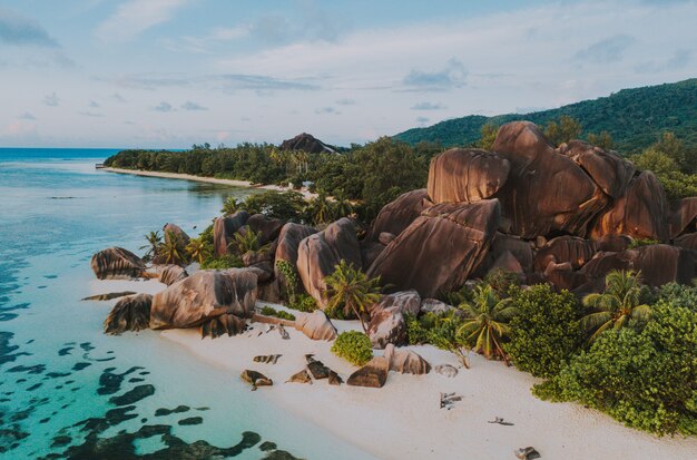 Ilha "La digue" nas Seychelles. Praia de prata com pedra granítica e selva. Vista aérea