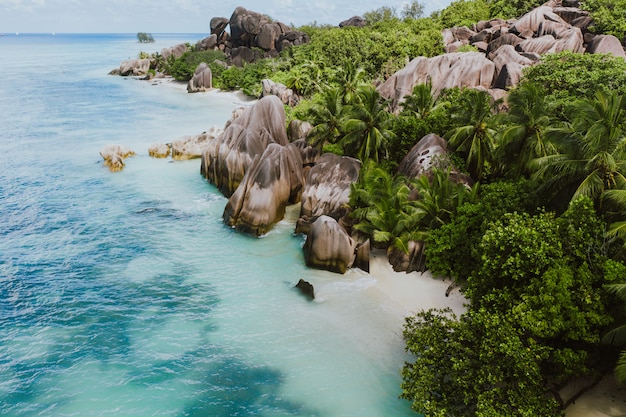 Ilha "La digue" nas Seychelles. Praia de prata com pedra granítica e selva. Vista aérea