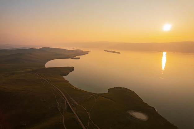 Ilha Olkhon ao nascer do sol, a maior ilha do Lago Baikal, no leste da Sibéria. Shamanka Rock no lago Baikal perto de Khuzhir na ilha Olkhon na Sibéria, Rússia.