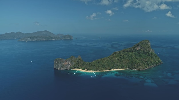 Foto ilha tropical na baía do oceano vista aérea barcos e navios no porto floresta tropical em ilha montanhosa