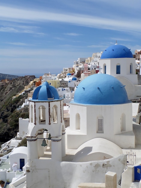 Foto ilhas gregas tradicionais igrejas brancas e azuis na vila de oia na ilha de santorini, grécia