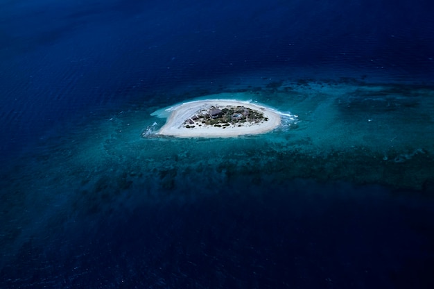 Ilhas Maldivas, vista aérea de um resort em uma pequena ilha cercada por recifes de corais