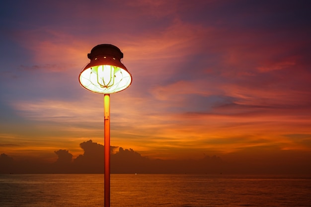 Foto iluminación de lámpara caliente o lámpara hid amarilla e iluminación de puesta de sol en el mar con cielo hermoso