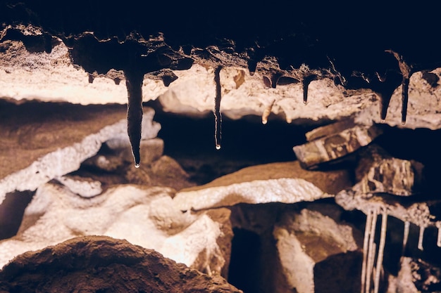 Foto iluminación oscura de formaciones de cuevas con estalactitas que gotean agua